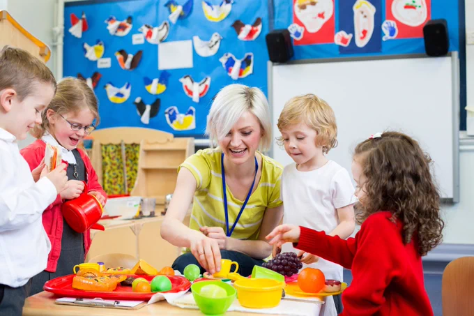 Children playing with a teacher