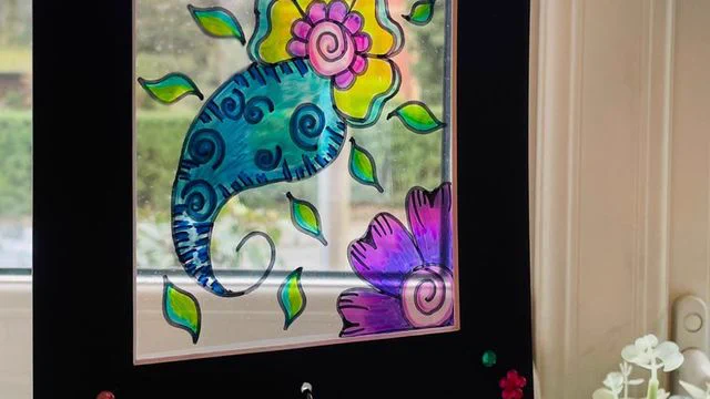 Colourful drawing of a plant on a framed piece of glass