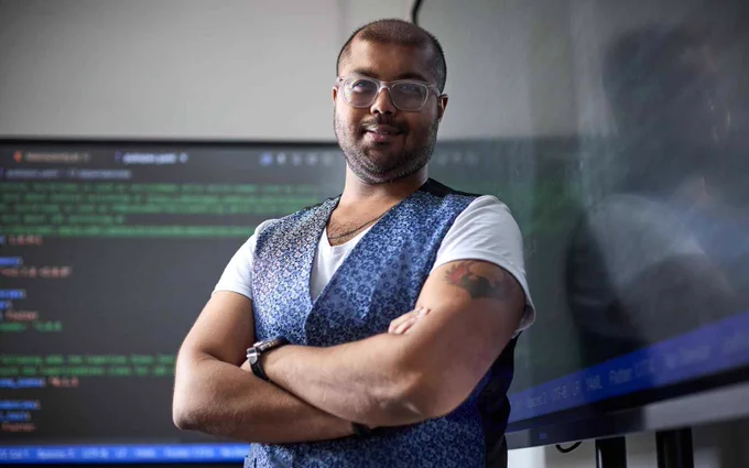 Image of Dr Somdip Dey in front of computer screens. 