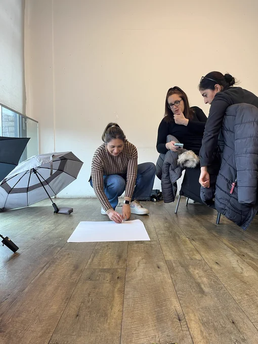 A group of people spinning a coin on a piece of paper on the floor