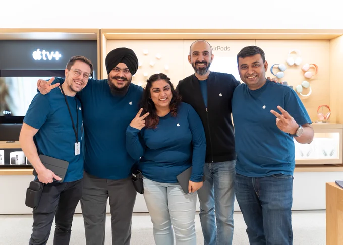 Five Apple retail employees posing together at Apple Saket.