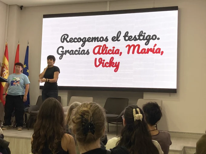 Val y Luz, organizadoras de PyLadies Madrid dando gracias a las organizadoras de la temporada anterior. 
En la pantalla: “Recogemos el testigo. Gracias Alicia, María, Vicky”