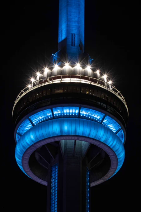 Closeup of the CN Tower at night lit in blue / Gros plan de la Tour CN de nuit, éclairée en bleu 