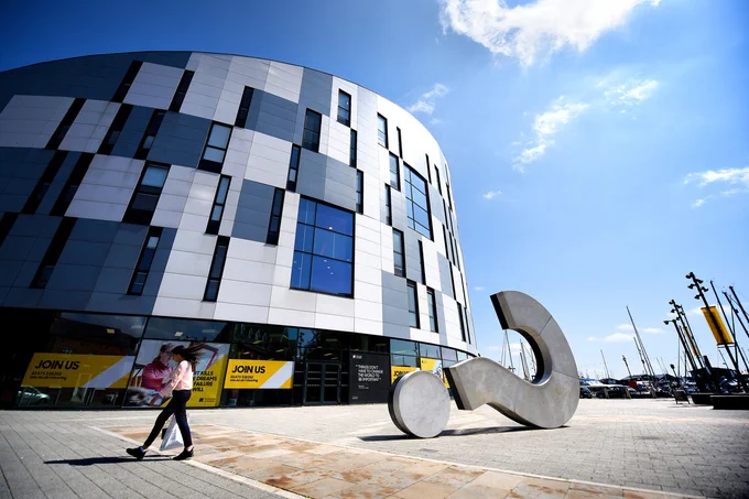 A photo of the outside of the Waterfront Building and question mark sculpture