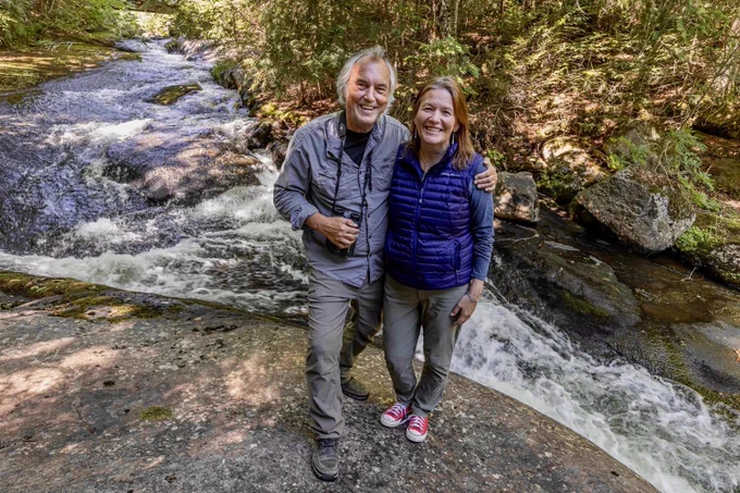 Mike Runtz and his partner Britta smile together near a river