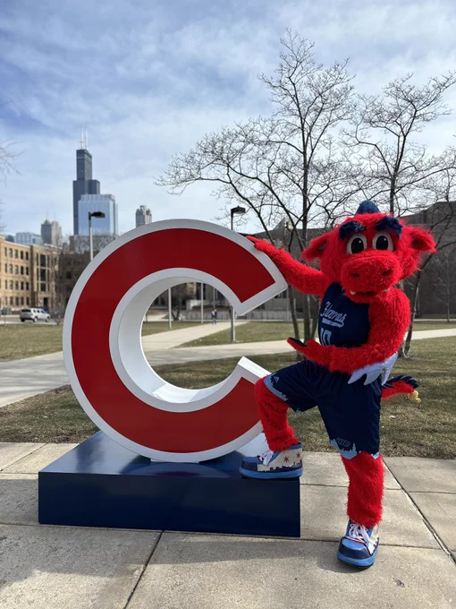 The UIC mascot Sparky poses with the Cubs logo in the UIC quad.