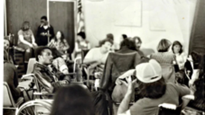 Image description: Lomax appearing pensive as he sits with others, many in wheelchairs. Lomax with other demonstrators inside the San Francisco Federal Building in April 1977

Image Credit: Glenn Lomax
