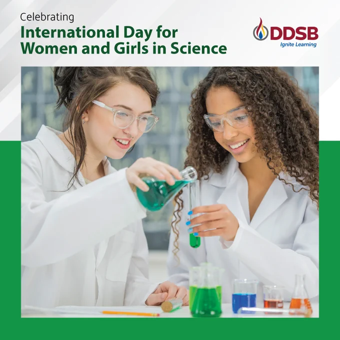 Two young females pouring liquid from a beaker into a test tube.