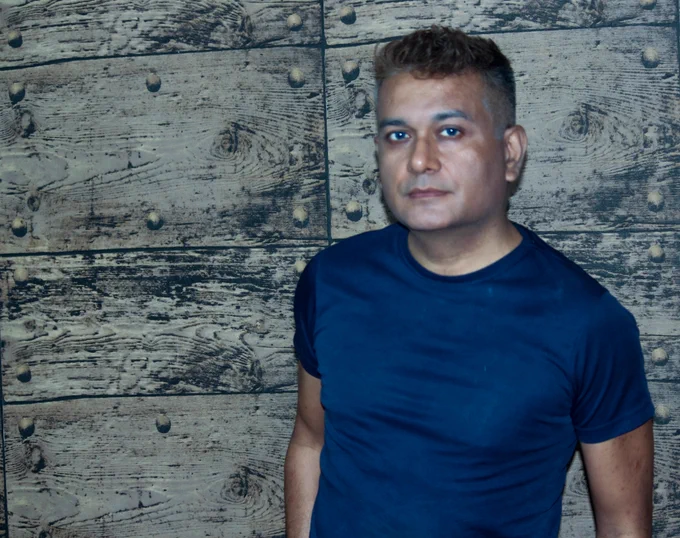Szebastian in a blue tee shirt, staring into the camera with a confident, yet calm look in the eyes. 