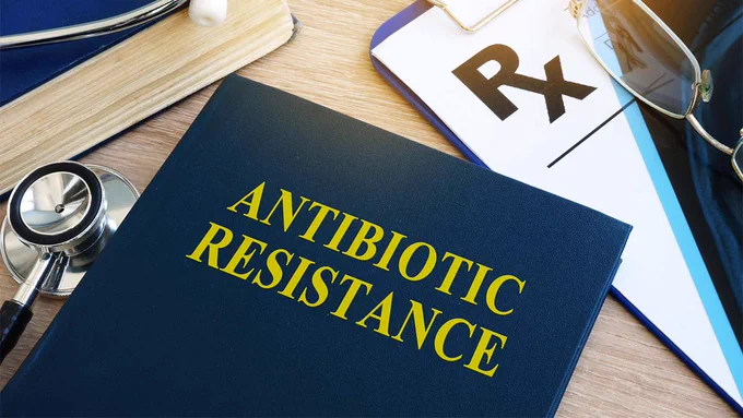 A clinician’s desk with a folder that reads, “Antibiotic Resistance.”