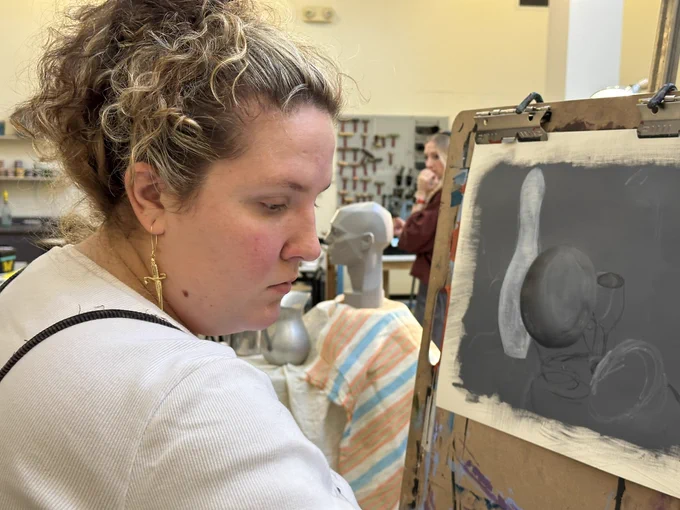 Student painting at an easel