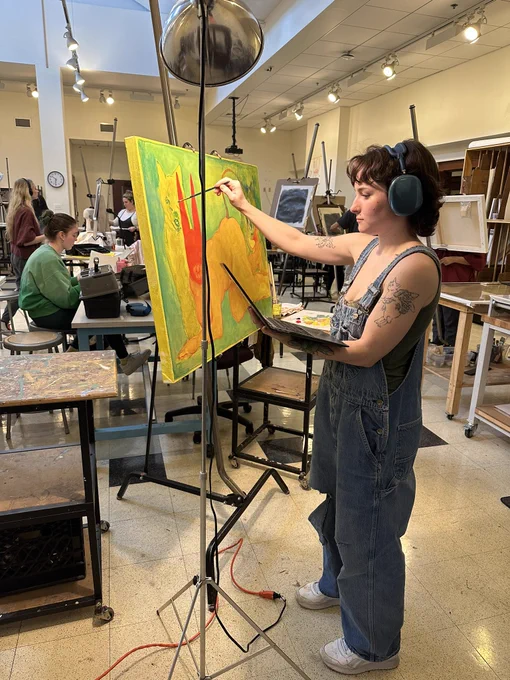 Student painting at an easel