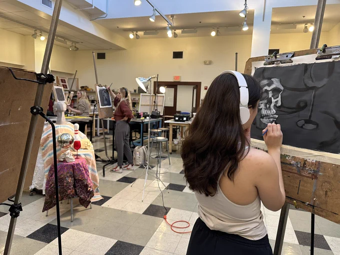 Student painting at an easel