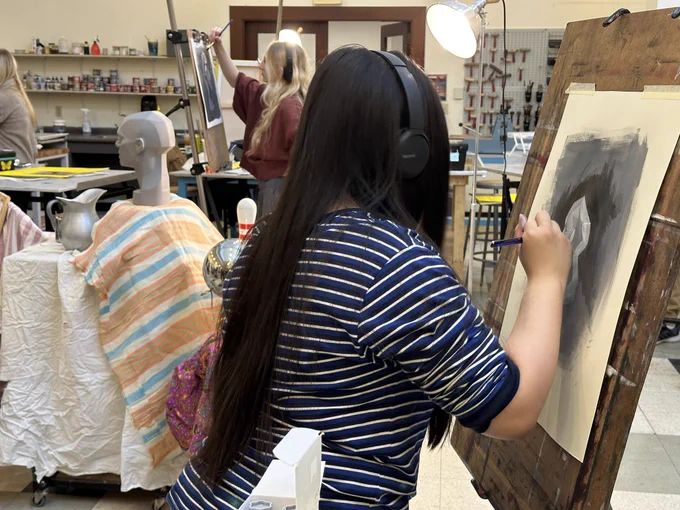 Student painting at an easel