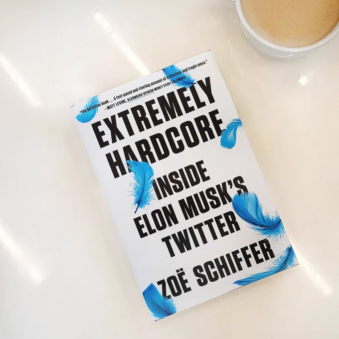 photo of EXTREMELY HARDCORE book on white marble background with white coffee mug