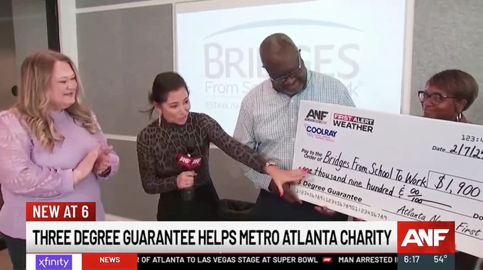 $1,900 check presentation with giant check and news reporter in the center.