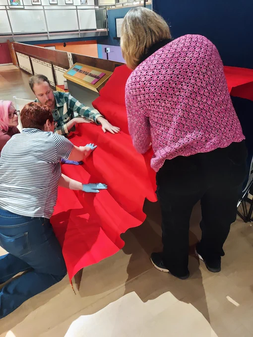 Here are four people adding red cloth to the stage.