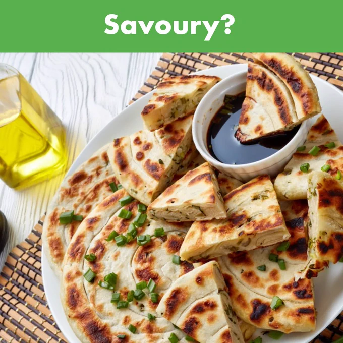 A plate of thick pancakes topped with chives. A banner at the top reads 'Savoury?'