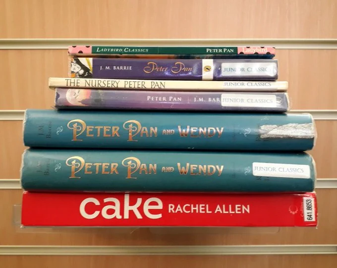 A stack of Peter Pan books on top of a book titled Cake