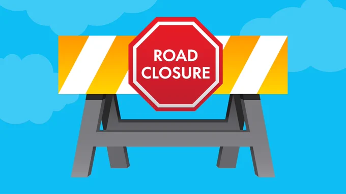 road barricade with road closure sign affixed to it