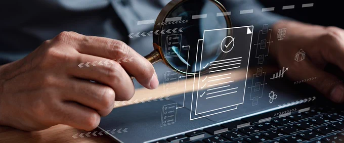 Person's hands on a laptop with graphics above showing tick lists 