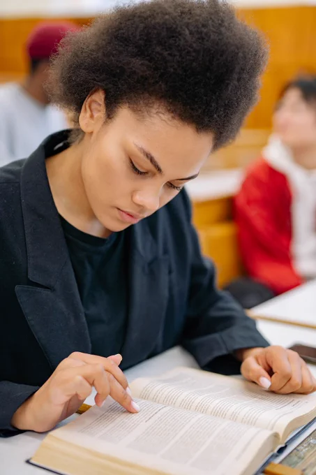 Photo d'une étudiante en train de lire avec un air concentré.