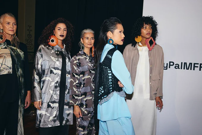 5 models wearing designs by First Nations fashion designers at the backstage of PayPal Melbourne Fashion Festival