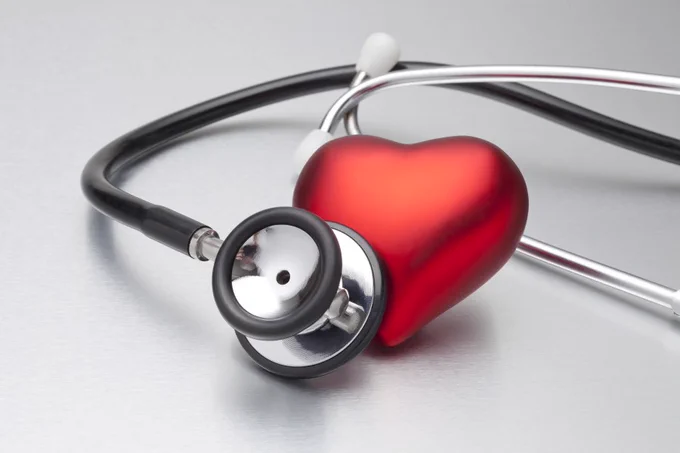 Stethoscope positioned over candy heart.