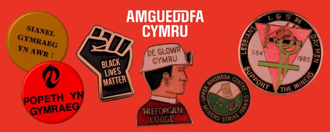 Bathodynnau pin gweithredwr a logo gwyn ‘Amgueddfa Cymru’ ar gefndir coch.