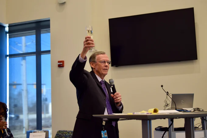 William (Bill) M. Tierney, MD, Associate Dean of Population Health & Health Outcomes, Clinical Professor, Department of Community and Global Health lifts a glass of sparking grape juice in a toast 
