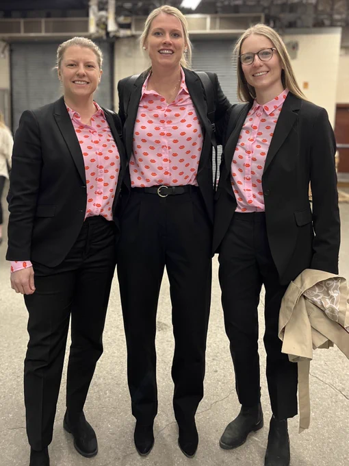 Coach Winberg (left) coach Kessel (center) and coach McKeough (right) wearing matching pink hear patterned shirts