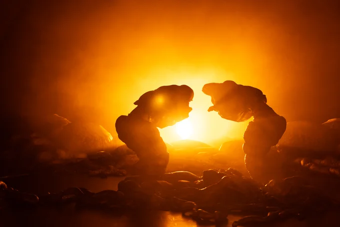 A moment from Justin Shoulder’s Anito: two 'creatures' are backlit by a bright golden light.