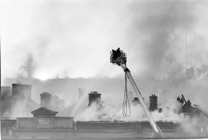 Vanhan ylioppilastalon tulipalo 1978. Palomiehet nostolavalla Vanhan ylioppilastalon katon yllä Helsingissä 8.4.1978. Kuvaaja Hannu Lindroos. JOKA Journalistinen kuva-arkisto, Museovirasto. CC BY-NC-ND 4.0
