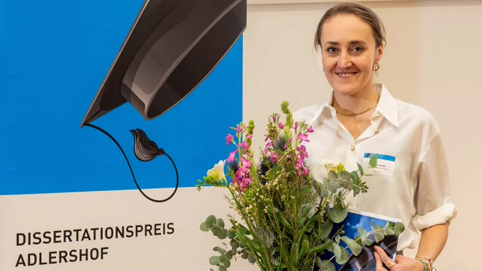 Dr. Lisa Kröll, Preisträgerin des Dissertationspreises Adlershof, mit einem Blumenstrauß in der Hand
Foto: IGAFA, Alexander Ney