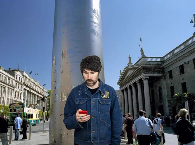 Gruff Rhys stood at the Spire, Dublin; reimagining a scene from his video for I Love EU.