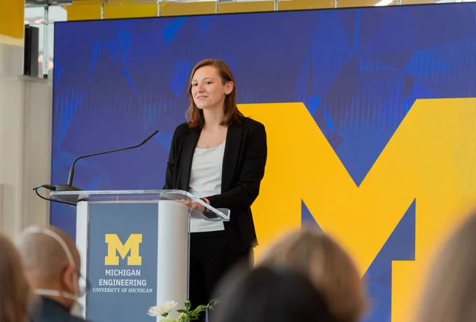 Andrea Sipos presents at a podium.