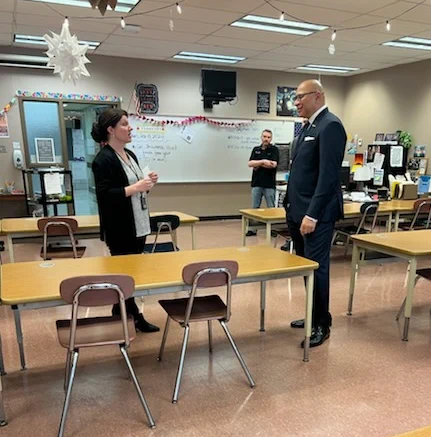 Two people talking in a classroom setting.