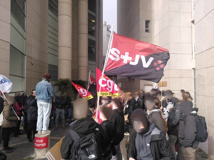 Piquet de grève du STJV le 14 février à Paris, drapeaux du STJV, de Solidaires Informatiques et de la CGT et une foule attroupée devant les locaux