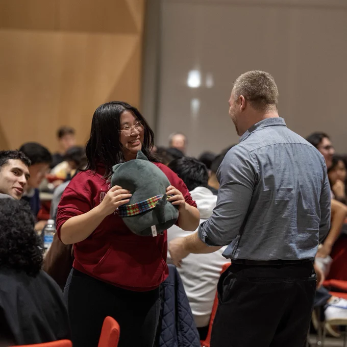 A young woman hugs a Scotty plush she won in a raffle.