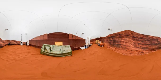 A 360-degree view inside the sandbox portion of the Crew Health and Performance Exploration Analog (CHAPEA) habitat at NASA’s Johnson Space Center in Houston. The walls are decorated with an image of the Martian landscape. Credit: NASA/Bill Stafford