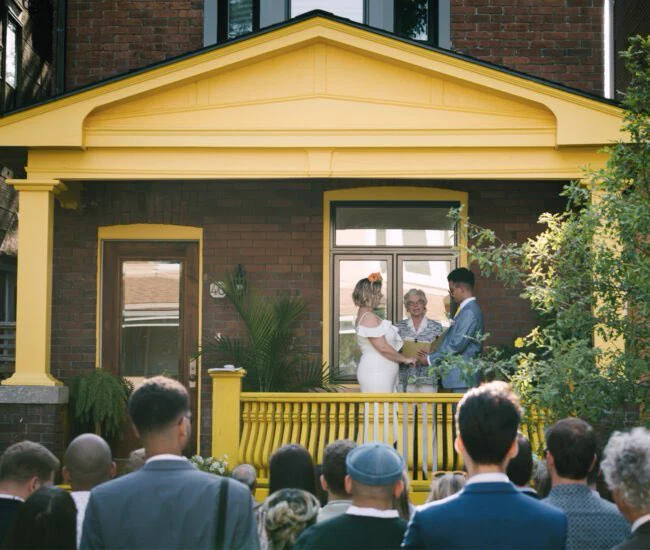Image of two people exchanging vows on their front porch