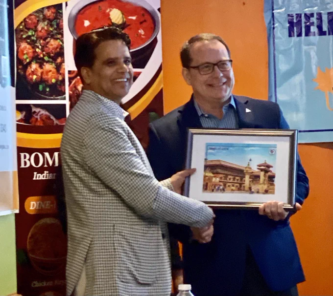 Mike receiving a framed photo as a token of love from Helping Hands president Rajan Chhatkuli