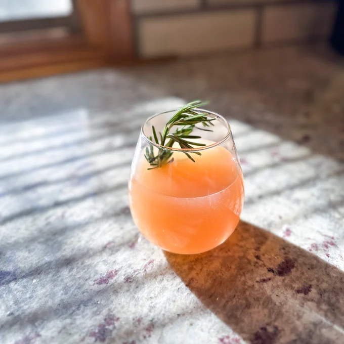 Grapefruit Rosemary Sparkler mocktail in a wine class.