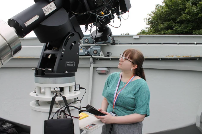 A University of Kent staff member looks up towards the Canterbury campus telescope