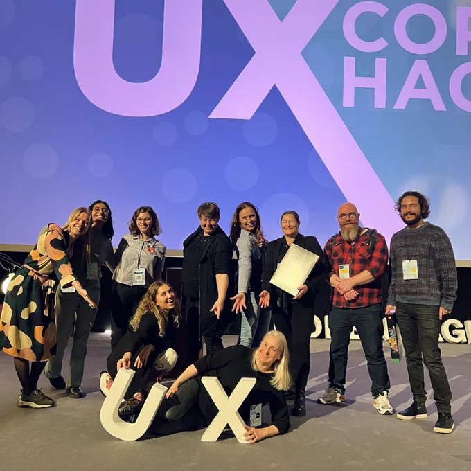 Image of the UX Copenhagen 2023 conference team with Helle Martens in front.  I believe you can tell from the picture that everyone looks excited and happy to be there. 
