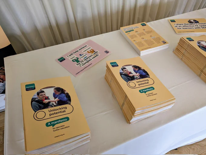 Copies of the Natspec manifesto laid out on a desk in stacks. 