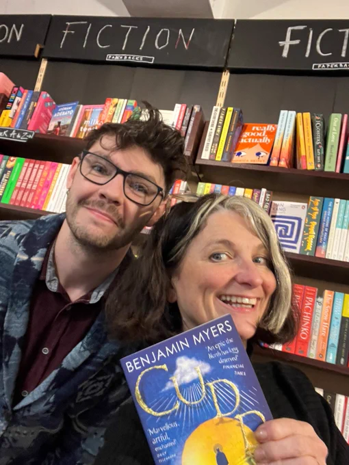 A photo of Jamie and Jo from Red Lion Books holding a copy of Cuddy by Benjamin Myers 