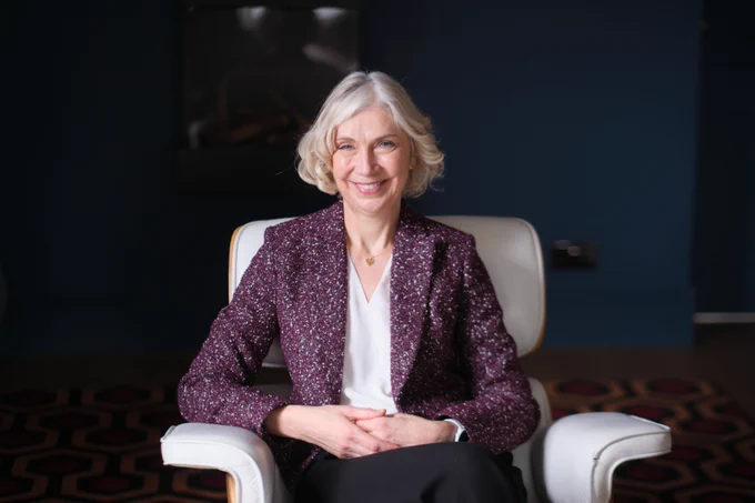 Professor Shan Wareing sitting in a white arm chair