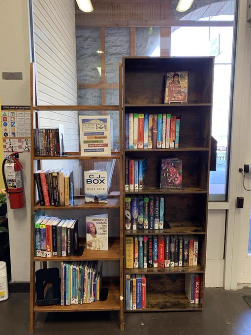  Bookshelves are filled with various books. Signs advertise for the Friends of the Pikes Peak Library District.