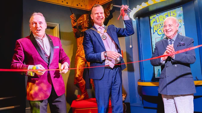 Andrew van Buren, the Mayor Simon White and Arthur Barnard cutting a red ribbon in front of a bronze, life sized statue of Philip Astley